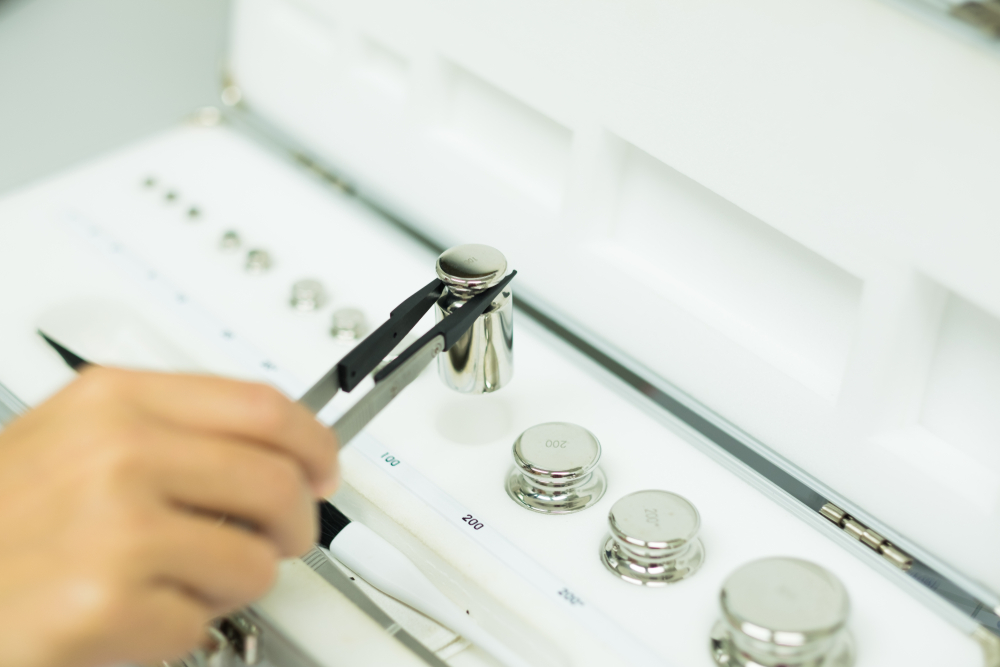 Operator's,Hand,Is,Holding,The,Stainless,Steel,Calibration,Weights,For