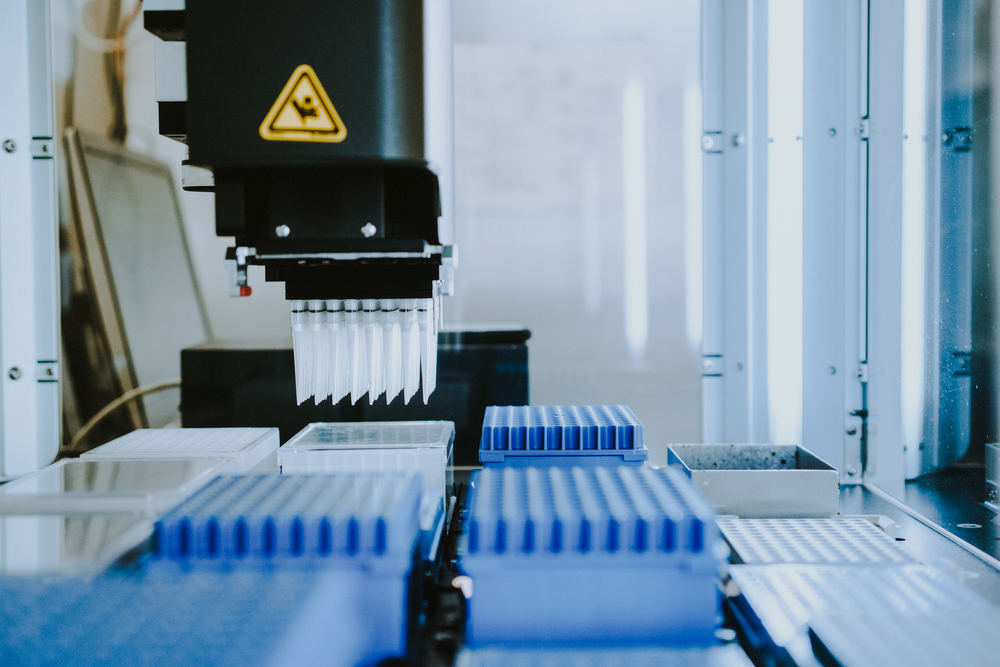 Robotic pipetting station with a multi-channel pipette positioned above various well plates for automated liquid handling.